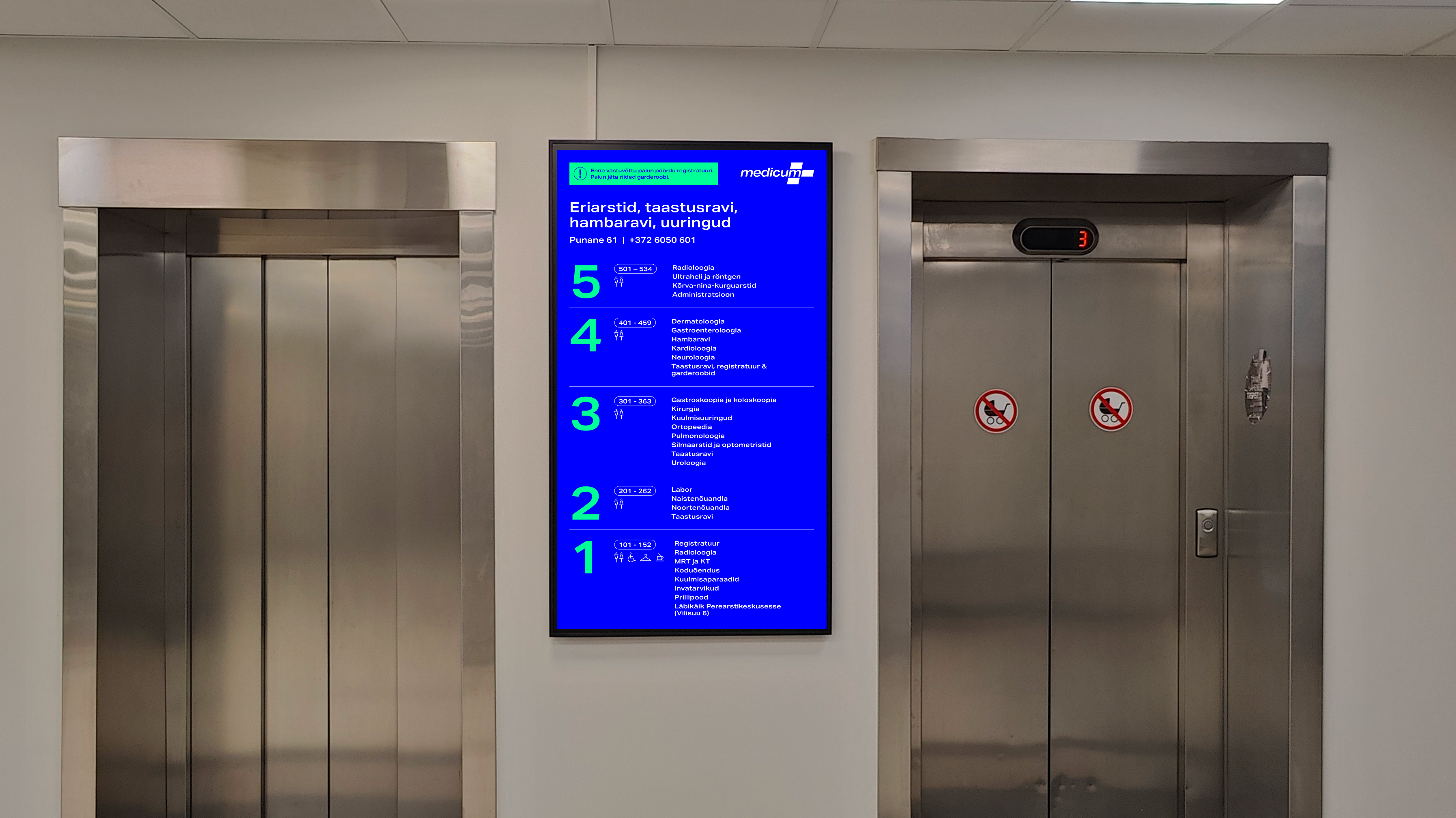 Digital wayfinding screen in a Medicum clinic showing the floor directory between two elevators