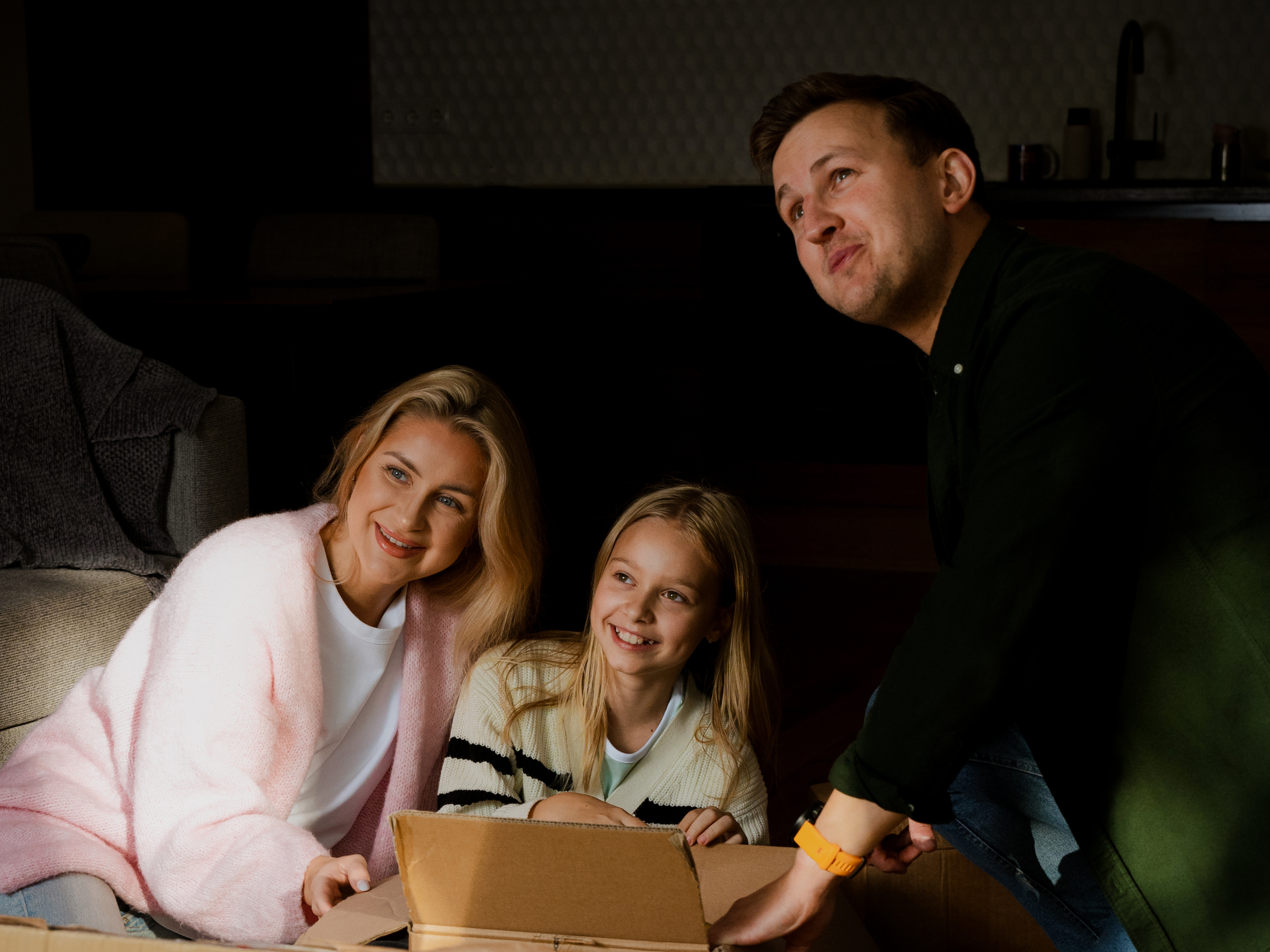A family opening a parcel at home together, from Modena's brand photography
