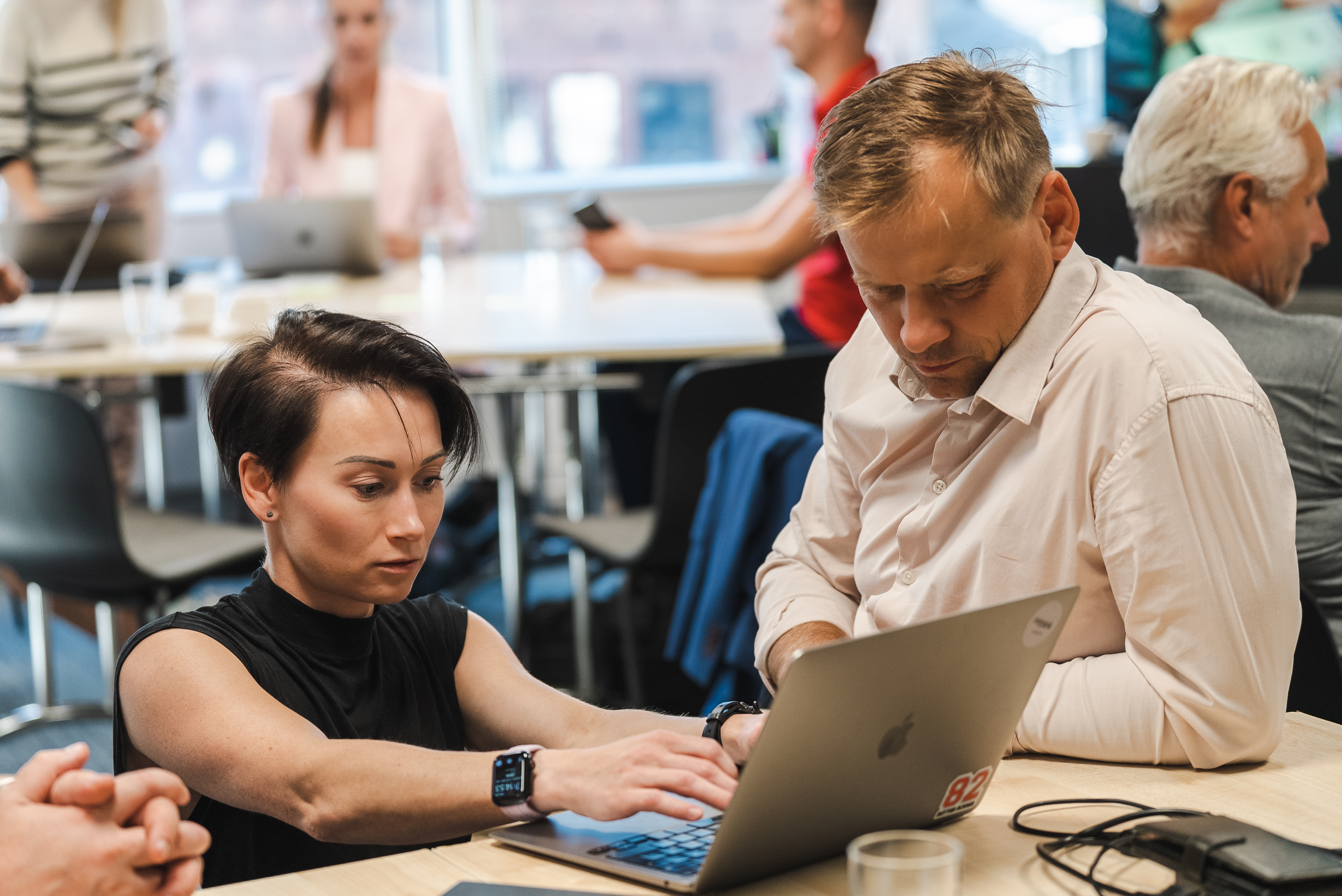 Two participants working together on a laptop during an SEB workshop