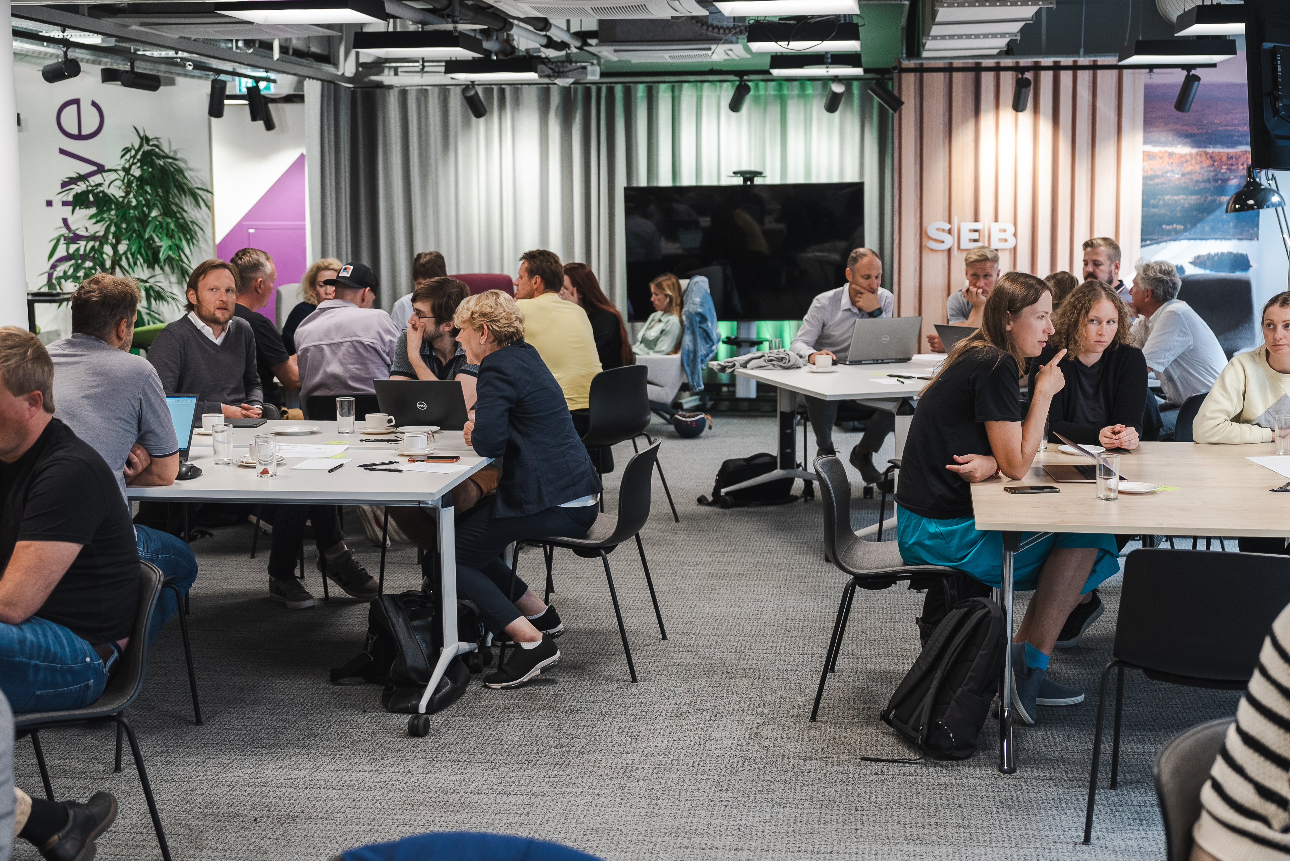 Participants collaborating at tables during an SEB workshop