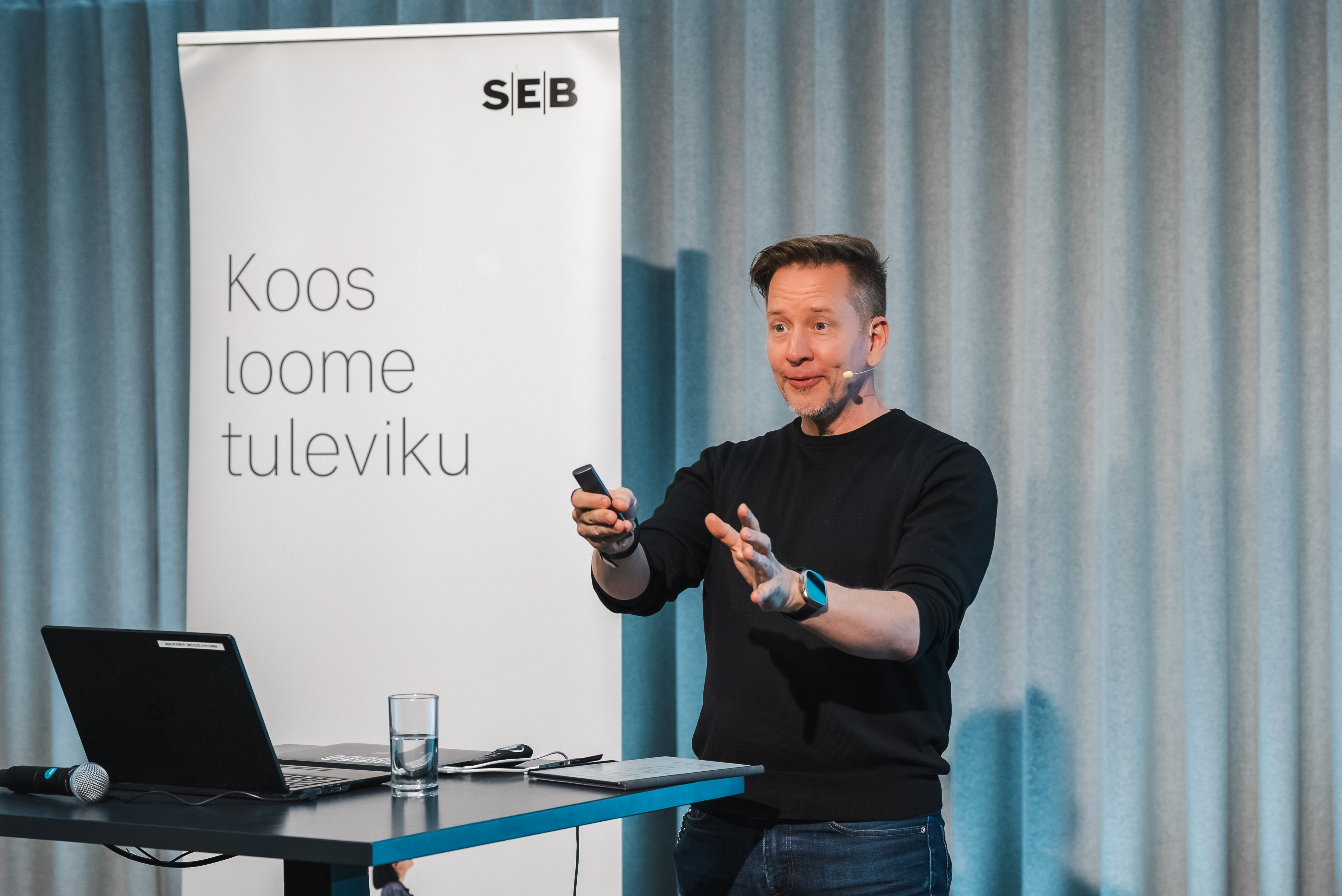 A speaker presenting beside an SEB 'Together we create the future' banner