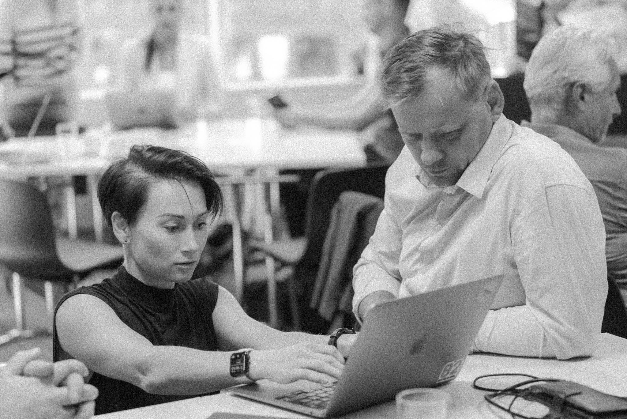 Two participants working together on a laptop during a training session
